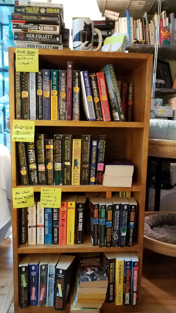 a wooden bookcase full of paperback novels