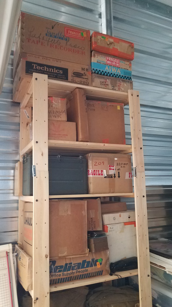 wood shelves with boxes of radio equipment